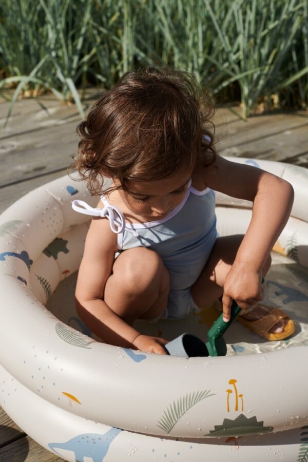 petite fille qui joue dans sa piscine gonflable liewood