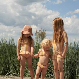 petites filles qui portent un maillot de bain une pièce jaune liewood