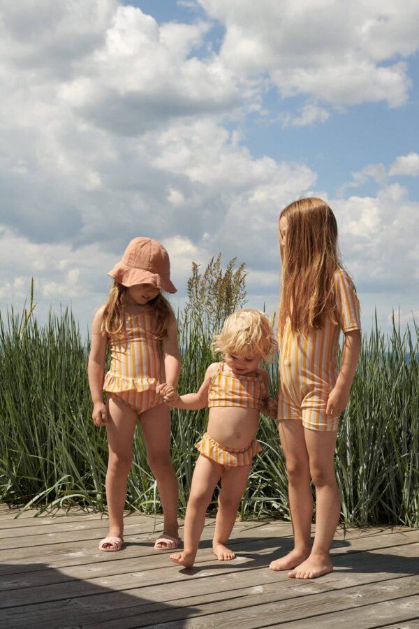petites filles qui portent un maillot de bain une pièce jaune liewood