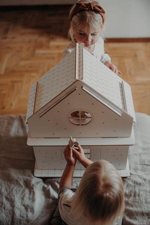 petites filles qui jouent avec leur maison de poupée en bois blanc