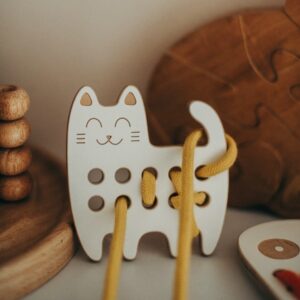 jouet à lacer en bois en forme de chat et son lacet de couleur jaune