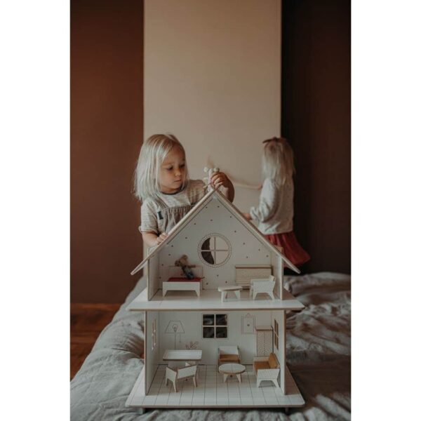 petite fille qui joue avec sa maison de poupée en bois vintage et les souris maileg
