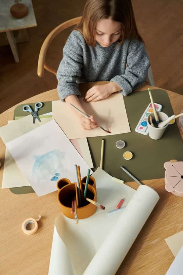petite fille qui fait de la peinture avec un pot à crayons caramel en silicone